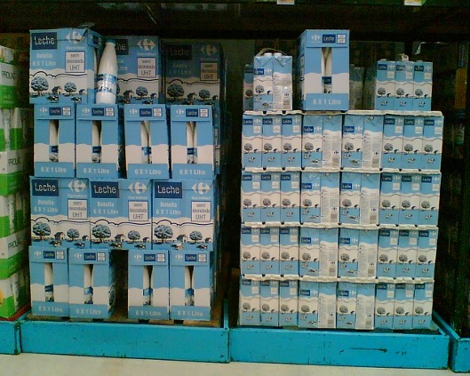 Palés de leche en brick expuestos directamente en el suelo del supermercado Carrefour